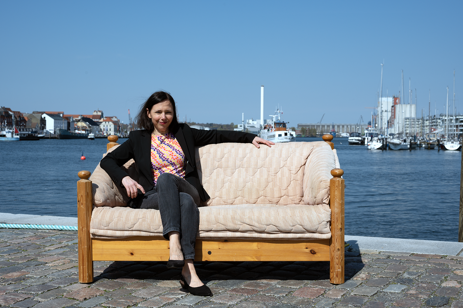 Angela Clemens sitzt am Flensburger Hafen auf einer Couch