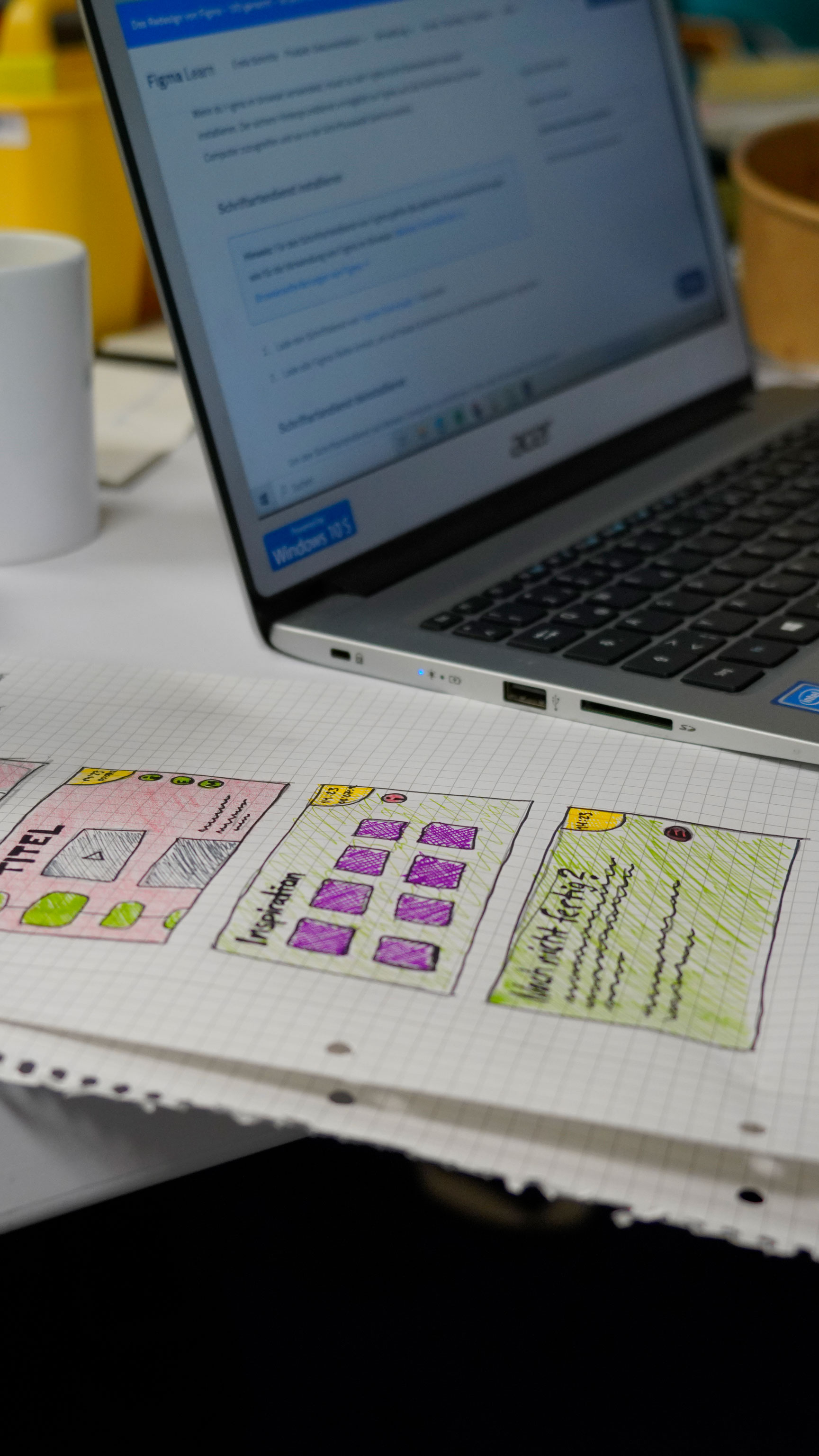 Nahaufnahme eins <laptops, neben dem ein Blatt mit gezeichneten Nutzungsoberflächen liegt.