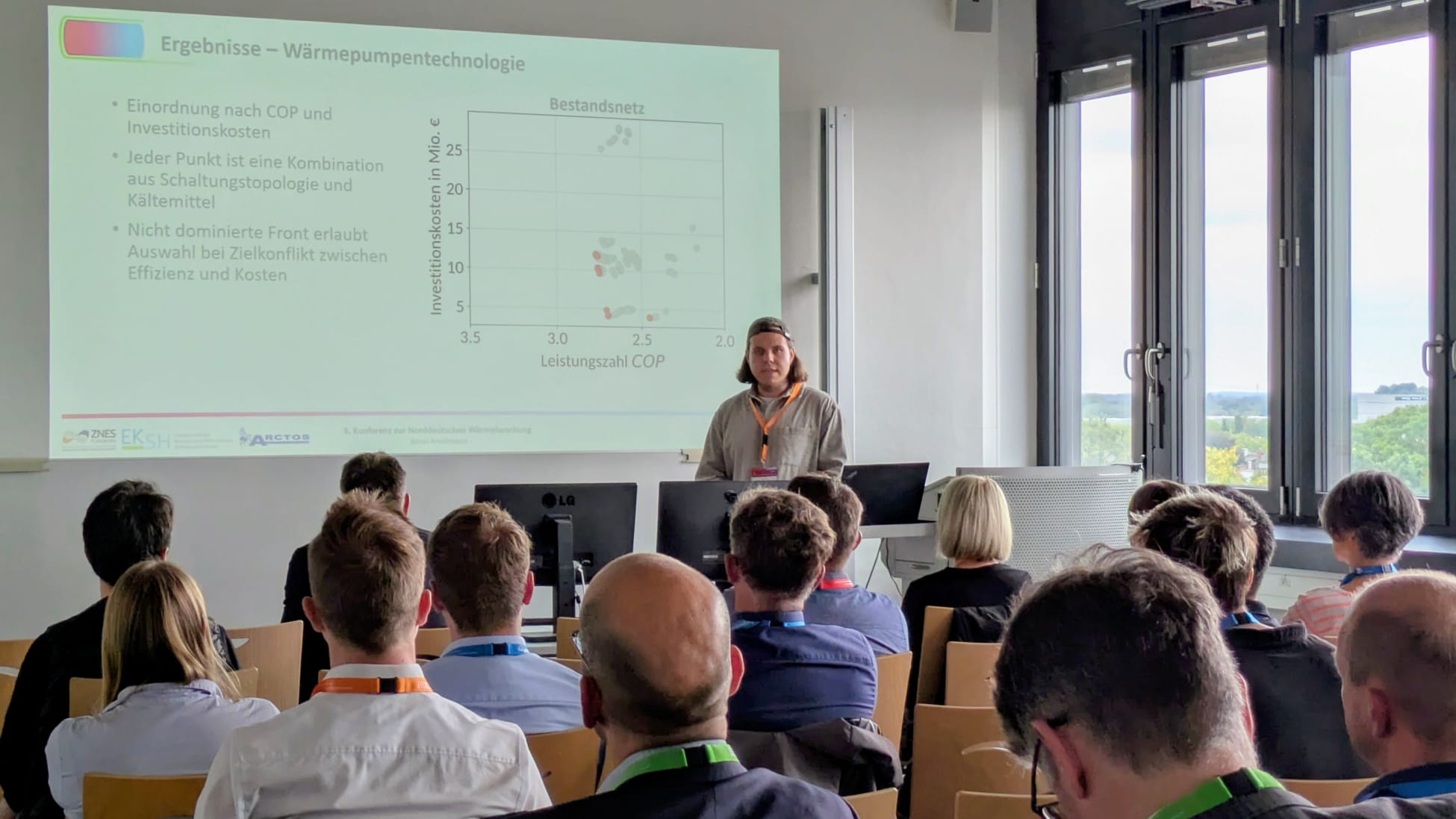 Konferenzsetting: Ein junger Mann spricht vor einem Publikum.