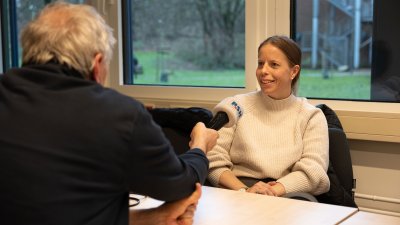 Britta Blotenbnerg spricht in ein Mikrofon, dass ihr ein Mann hinhält. 