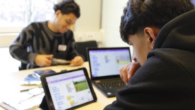 Man sieht einen verschwommenden Bildschirm, vor dem eine PErson sitzt