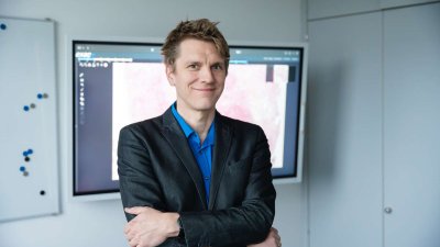 Marc Aubreville mit verschränkten Armen vor einem Bildschirm