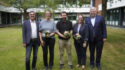 Fünf Menschen stehen auf der Wiese