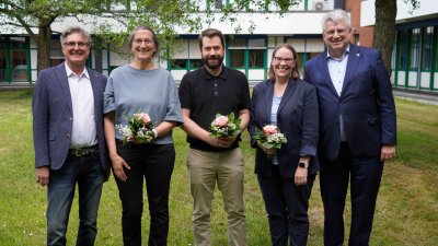 Fünf Menschen stehen auf der Wiese