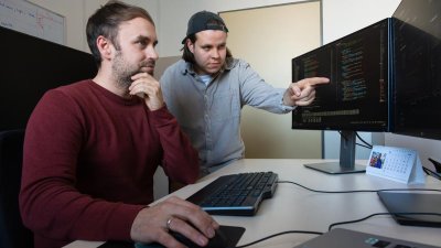 Zwei Menschen schauen auf einen Bildschirm