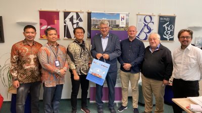 sieben Männer stehen im Halbreis und schauen in die Kamera