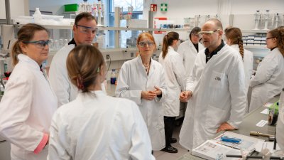 Viele Menschen in weißen Kitteln im Labor