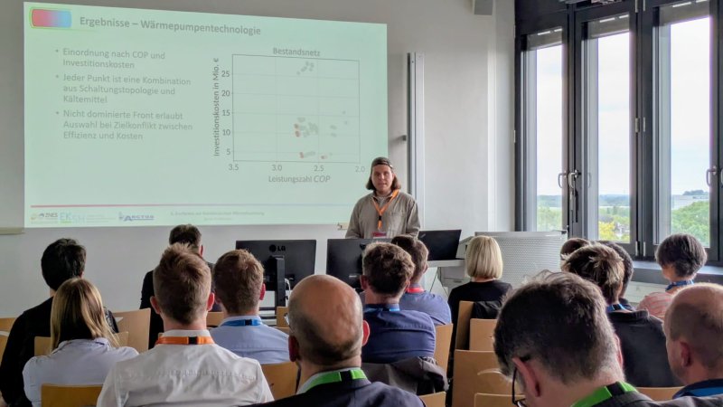 Ein Mensch steht vor einem Publikum und redet