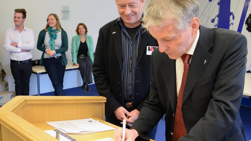 Hochschulpräsident Prof. Dr. Holger Watter unterzeichnet die Lübecker Erklärung im Beisein von Andreas Witolla, Landesvorstand des Lesben und Schwulenverbands in Deutschland. Foto: Gatermann