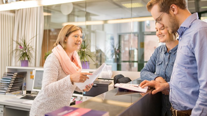 Studierende und Mitarbeiterin am InfoPoint