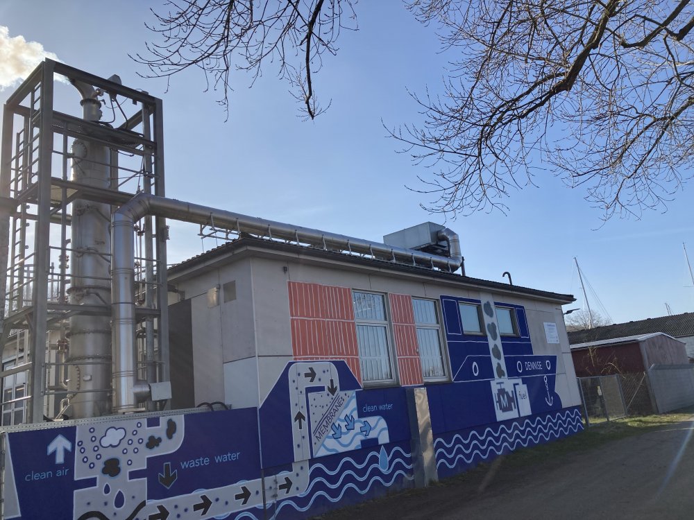 Gebäude vcor blauem Himmel; an der Außenwand das Grafitti eines Schiffes.