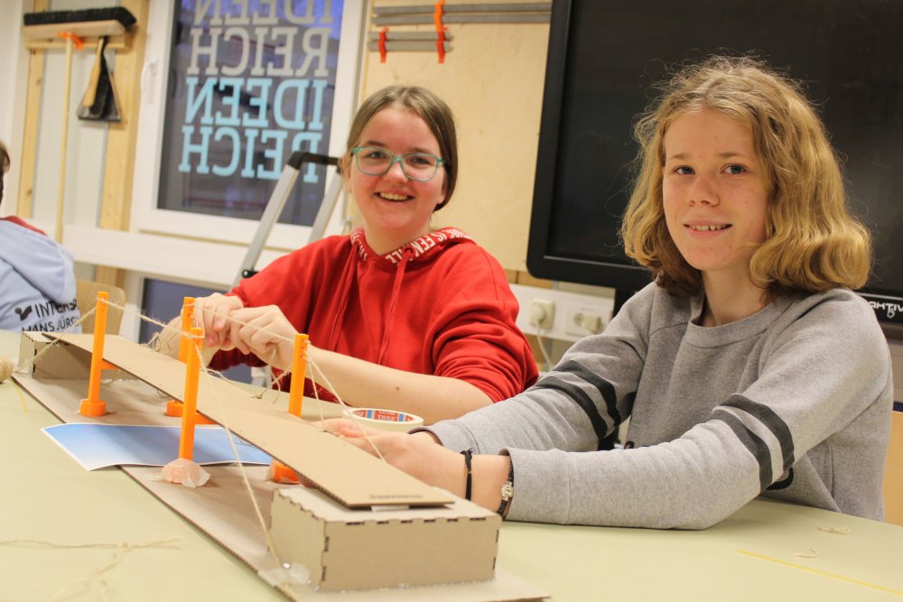 Zwei Mädchen hinter ihrer Brücke. Sie lächeln für die Kamera.