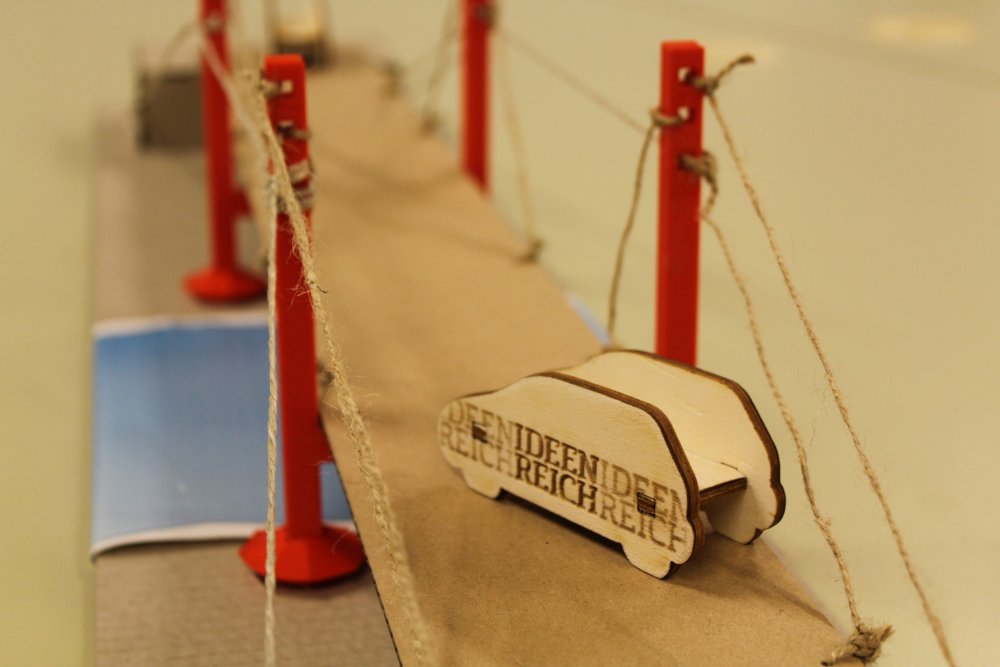 Holzauto auf einer Brücke.