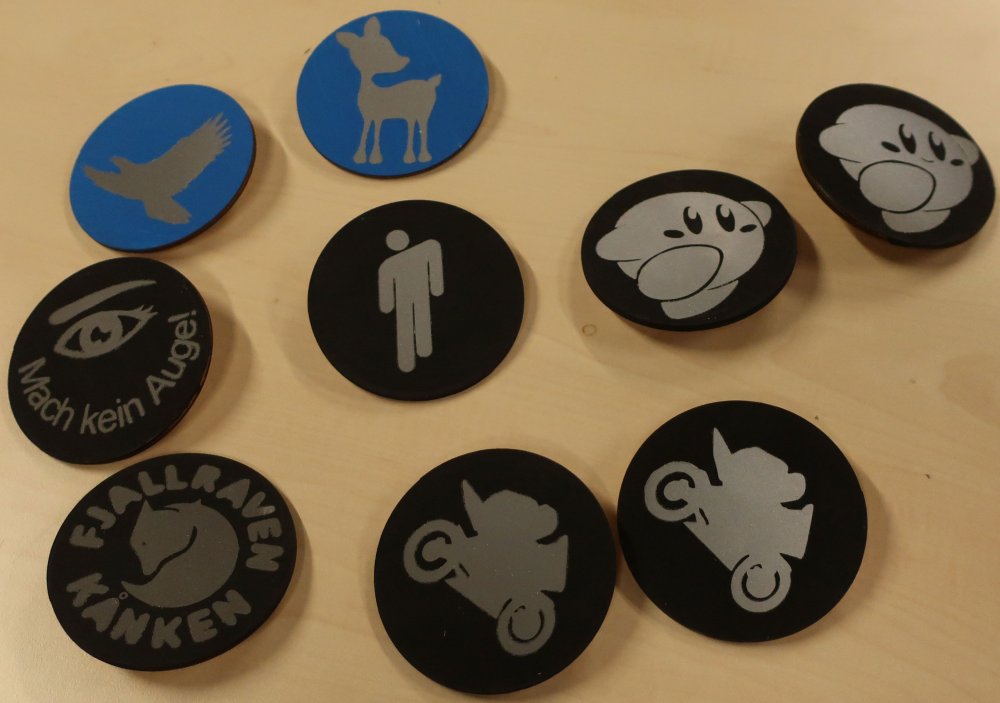 Mehrere Reflektorbutton smit verschiedenen Motiven auf einem Tisch.