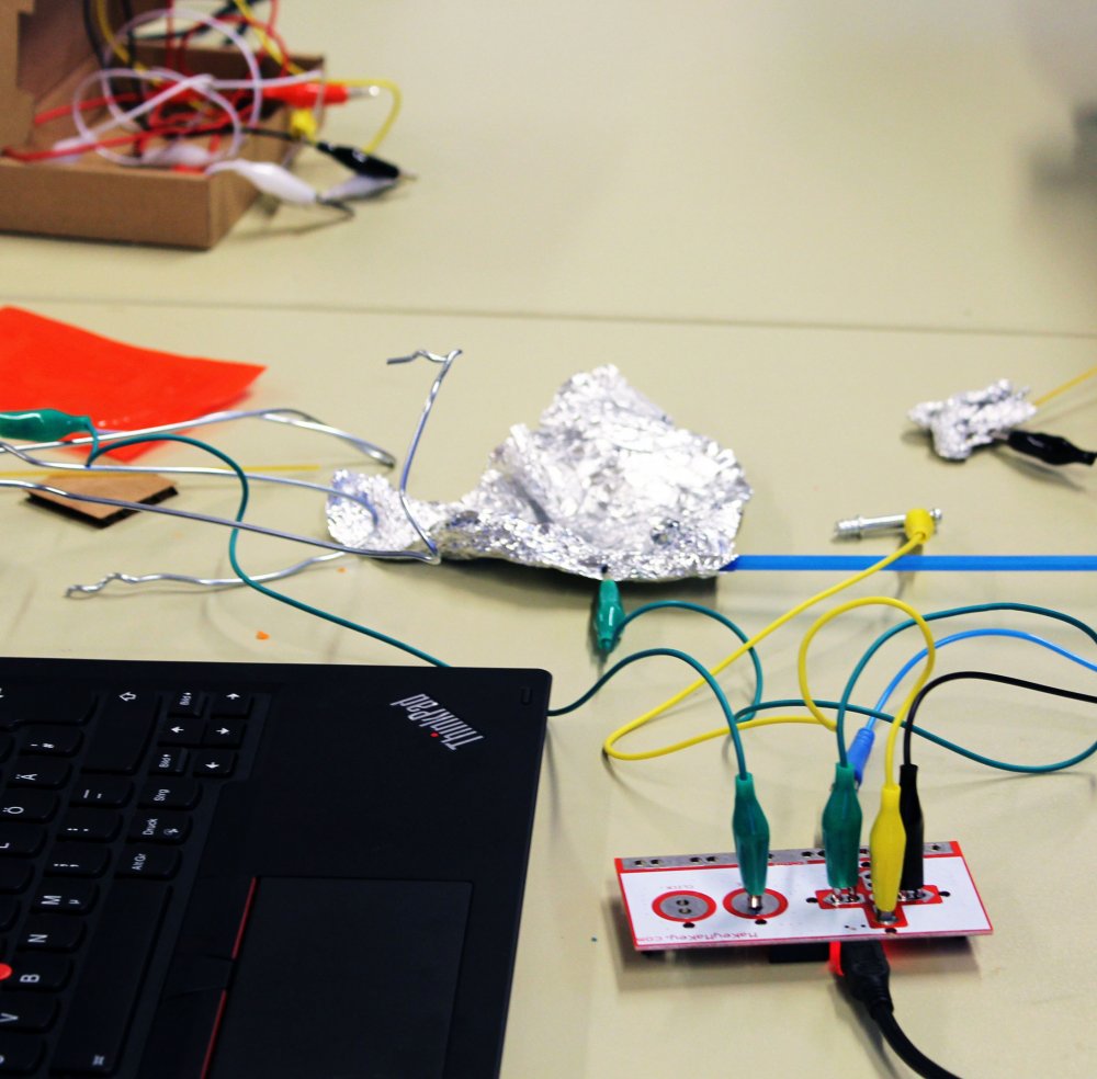 Kabel an eine Platine gesteckt, Laptop und andere Utensilien.