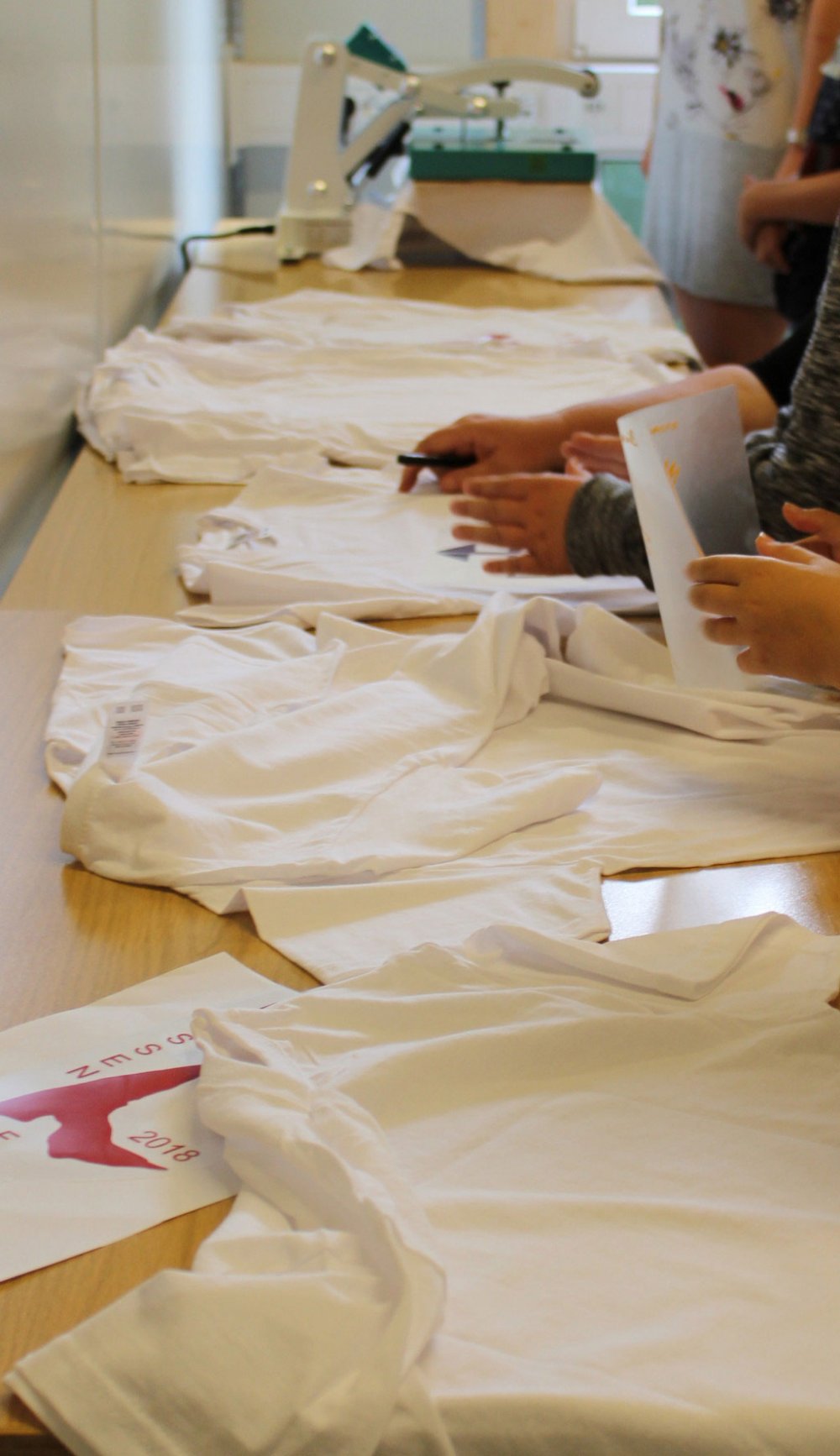 Länglicher Tisch, an dem an an Shirrts gearbeitet wird.