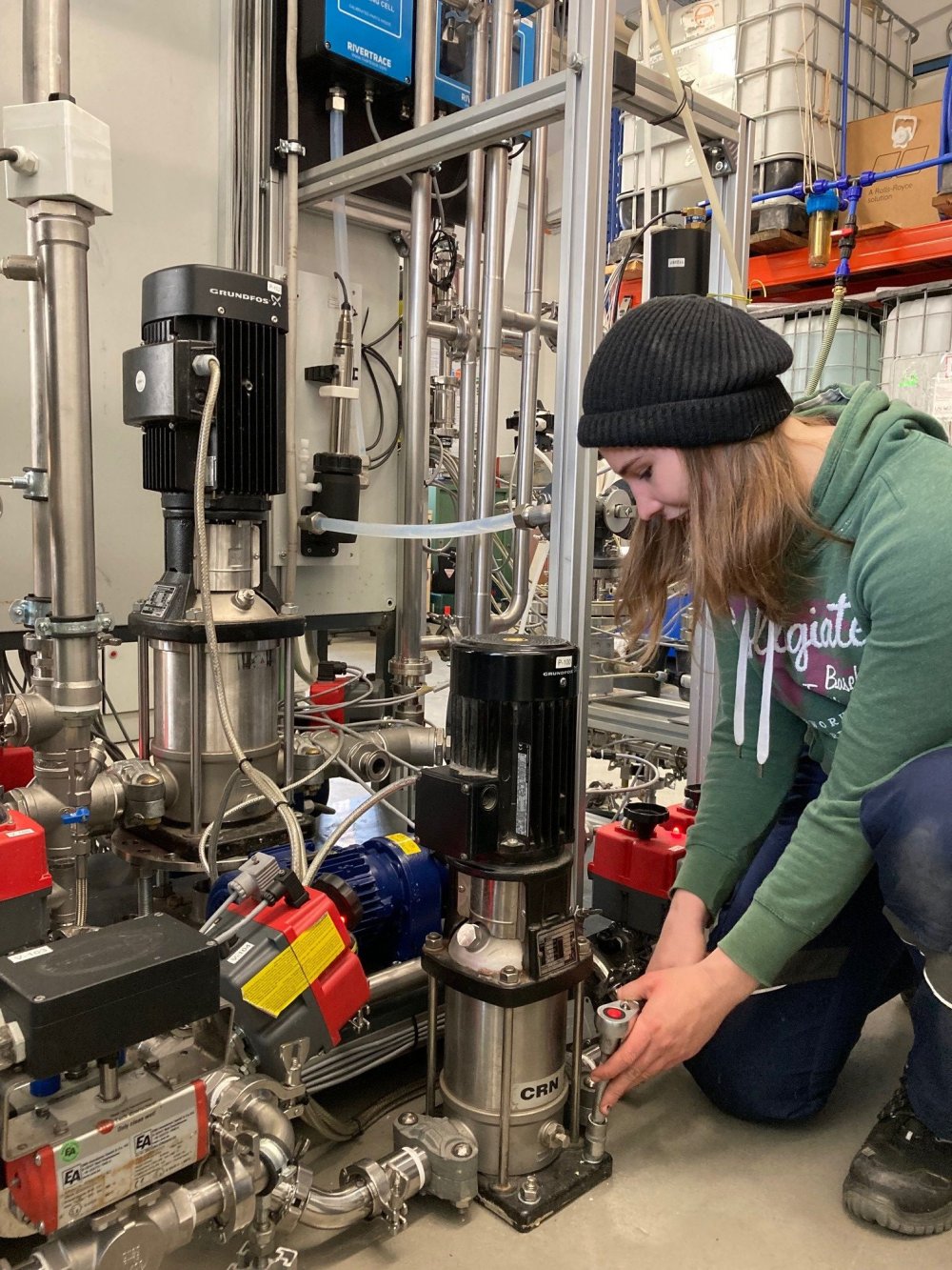 Junge Frau arbeitet an einer technischen Anlage.