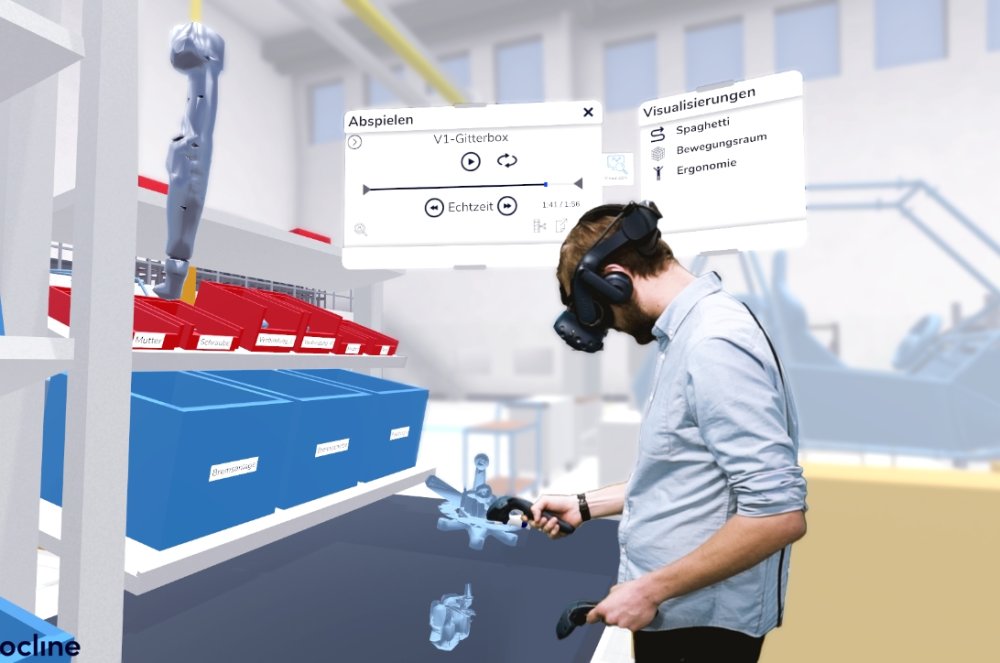 Ein Produktionsplaner mit einer VR-Brille und zwei Controllern innerhalb eines computersimulierten Produktionsarbeitsplatzes.