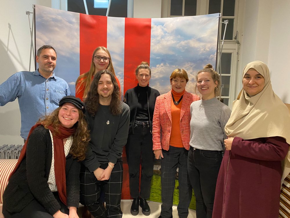 Gruppe verschiedener Menschen lächelt in die Kamera.