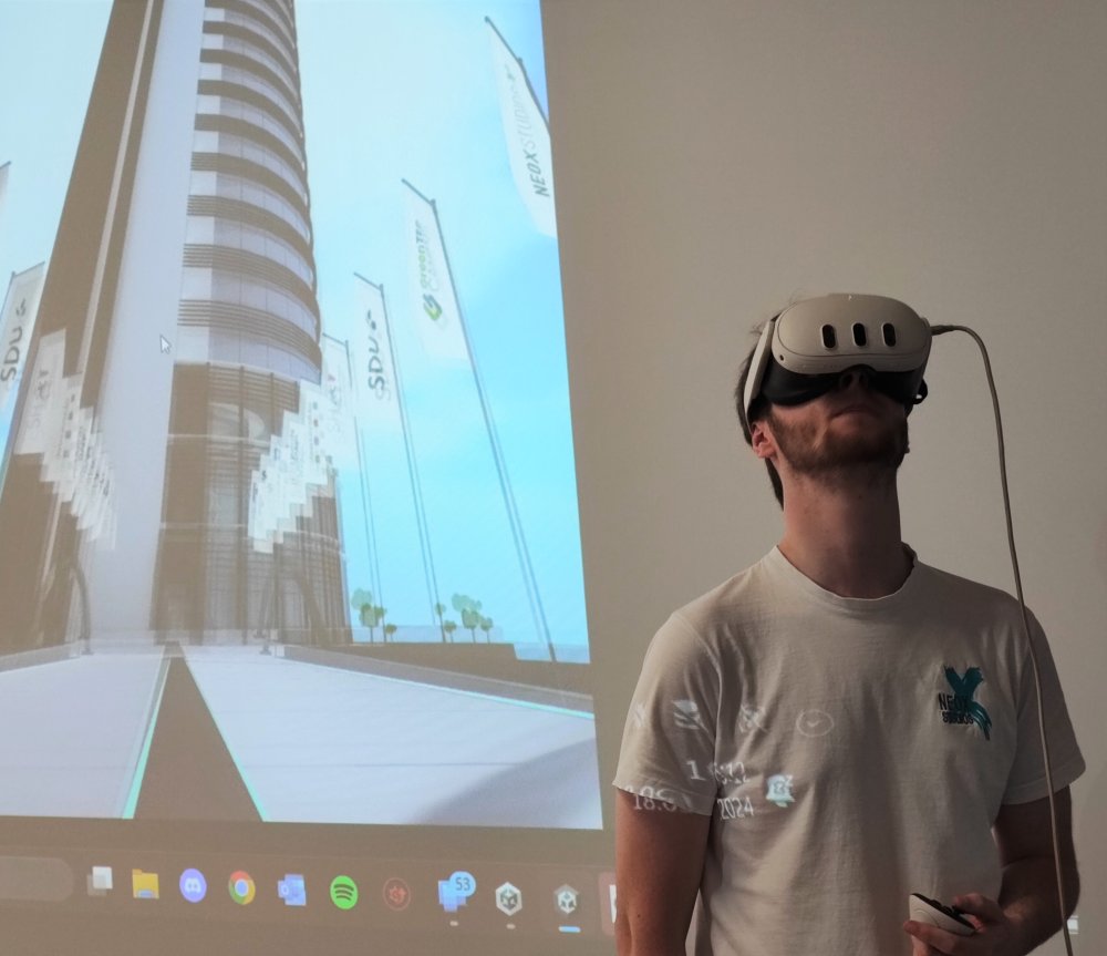 Ein Mann mit VR ist vor einem Bildschimr zu sehen