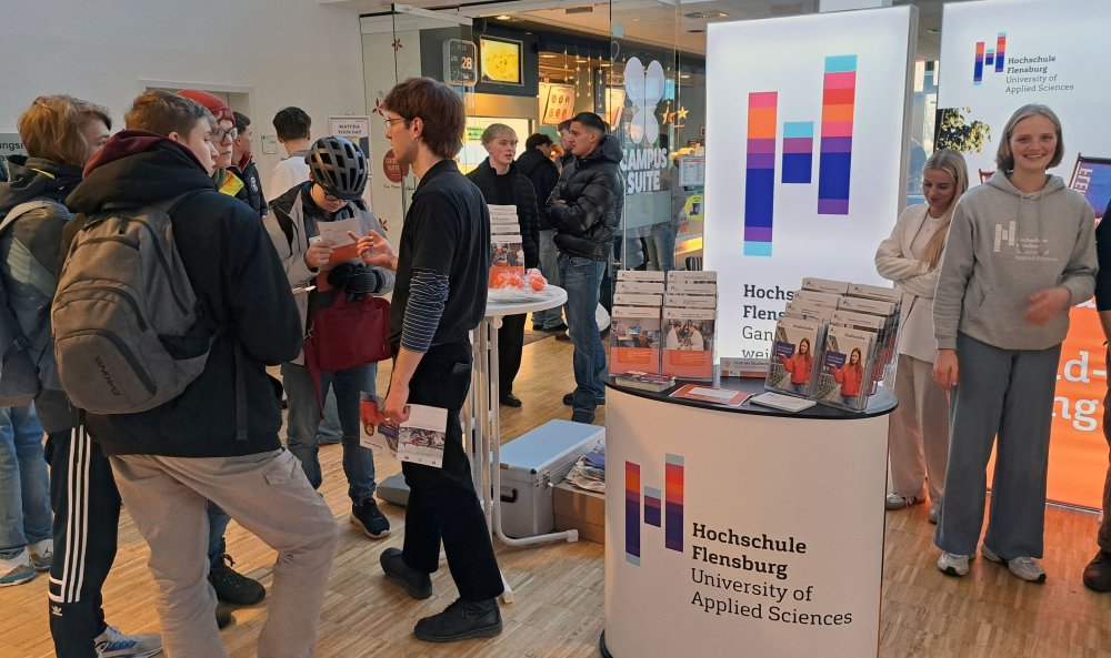 Man sieht viele Menschen an einem Infostand.