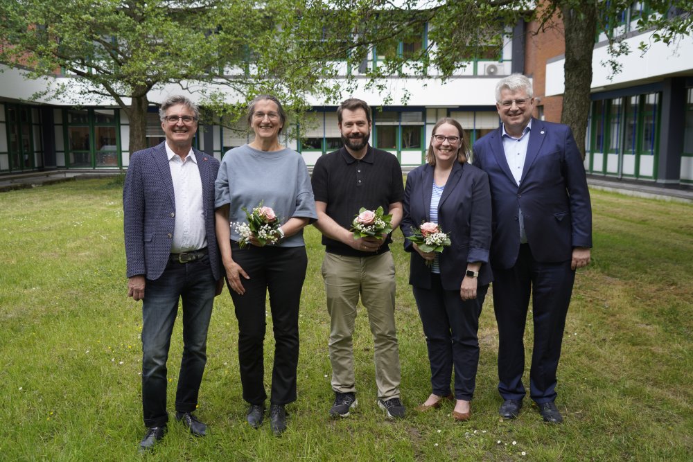Fünf Menschen stehen auf der Wiese