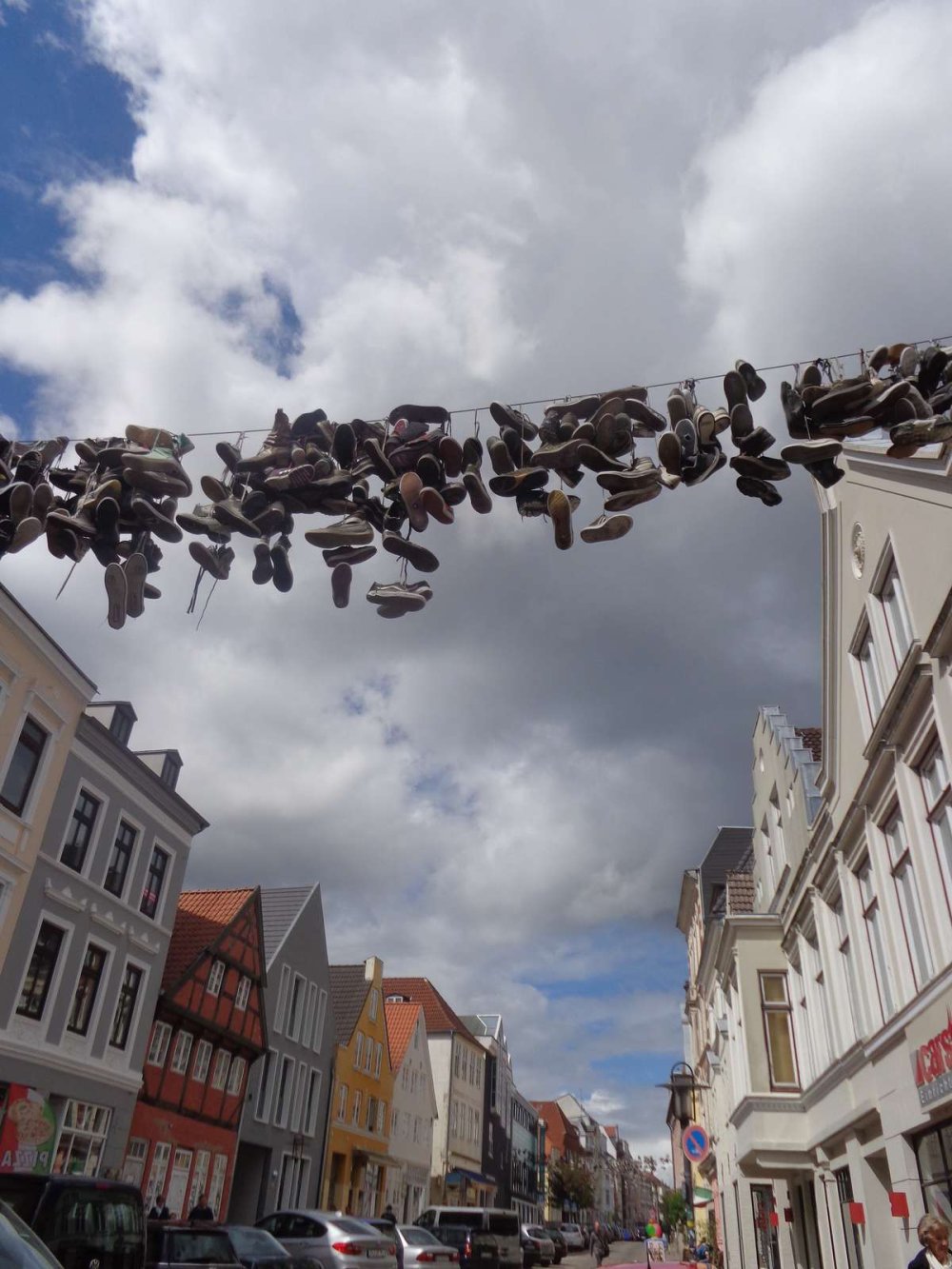 Bild von der Flensburger Norderstraße mit einer Leine, an der zahlreiche Schuhe hängen.