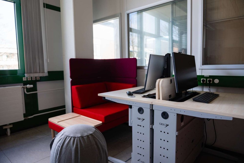 PC-Arbeitsplatz mit einer roten Sitzecke.