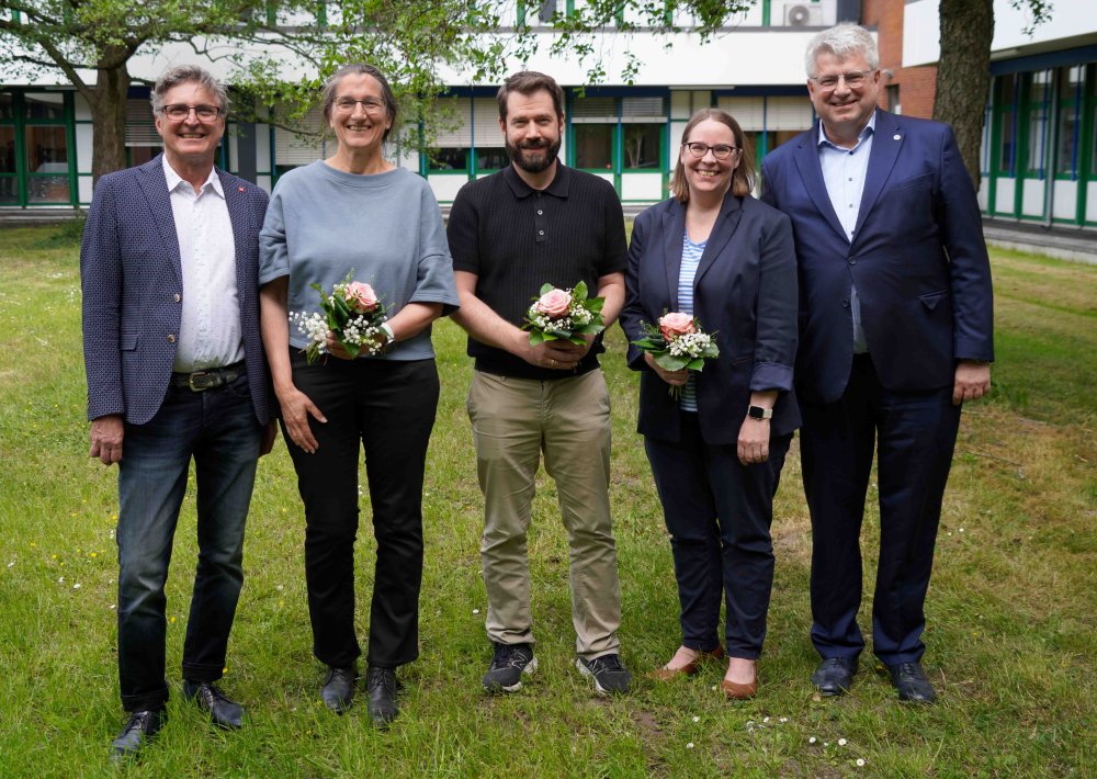Fünf Menschen stehen auf der Wiese