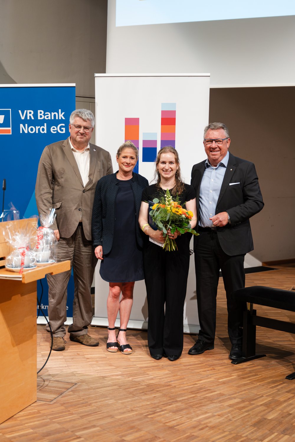 Mit der ausgezeichneten Leony Dietz freuen sich Hochschulpräsident Sven Tode (li), die betreuende Professorin Nelly Oelze und Hauke Präger von der VR Bank Nord. – Foto: Mirco Höfer