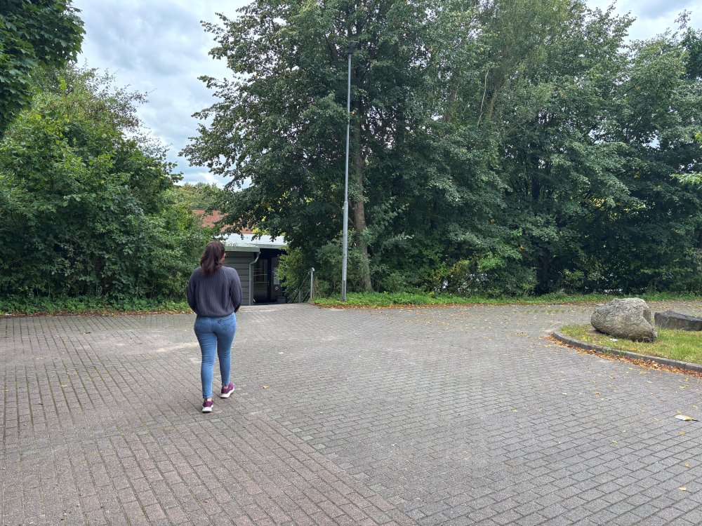 Eine Frau geht über einen Parkplatz
