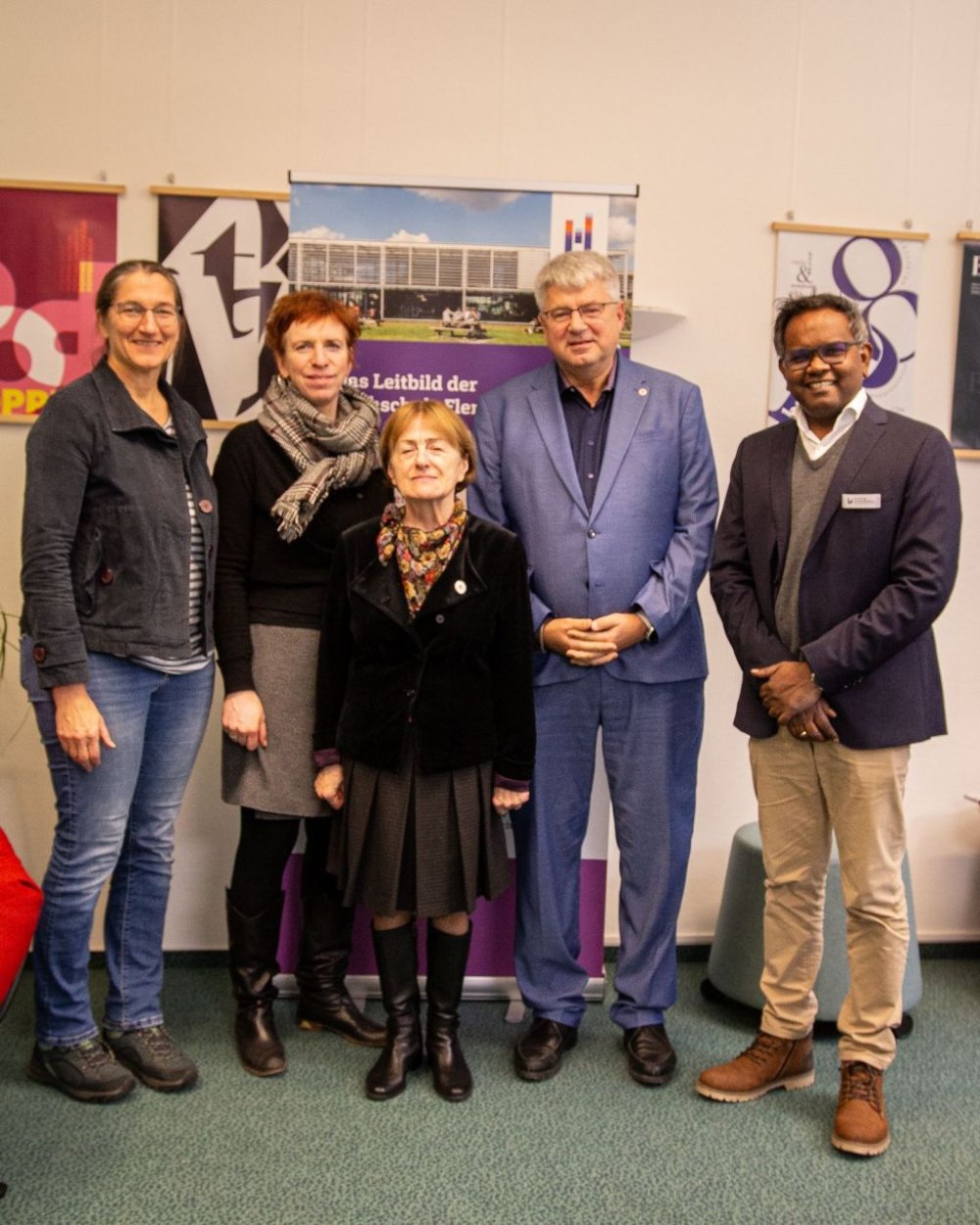 Fünf Menschen stehen nebeneinander und schauen in die Kamera