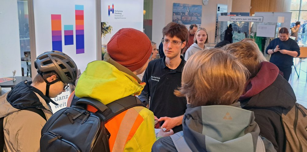 Viele Menschen schauen zu einem Menschen. 