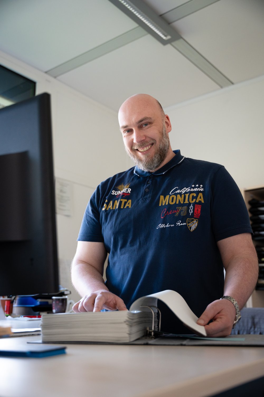 Ein Mann steht hinter einem Tisch und schaut von oben in die Kamera