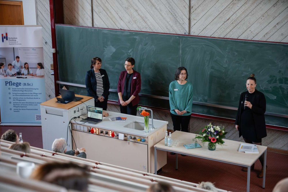 Vier Frauen vor einer grünen tafel