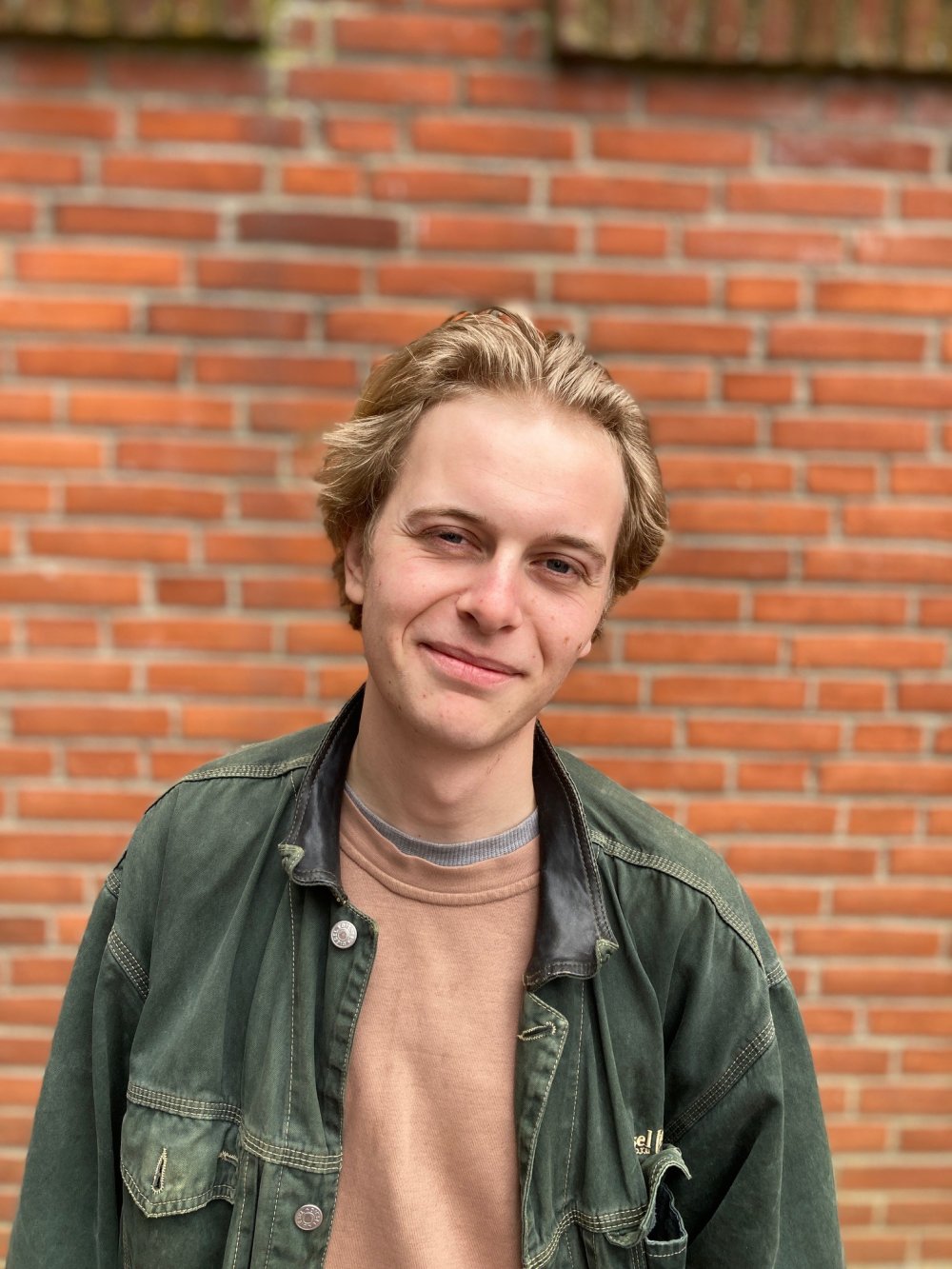 Ein mann schaut in die kamera vor roter Ziegelwand