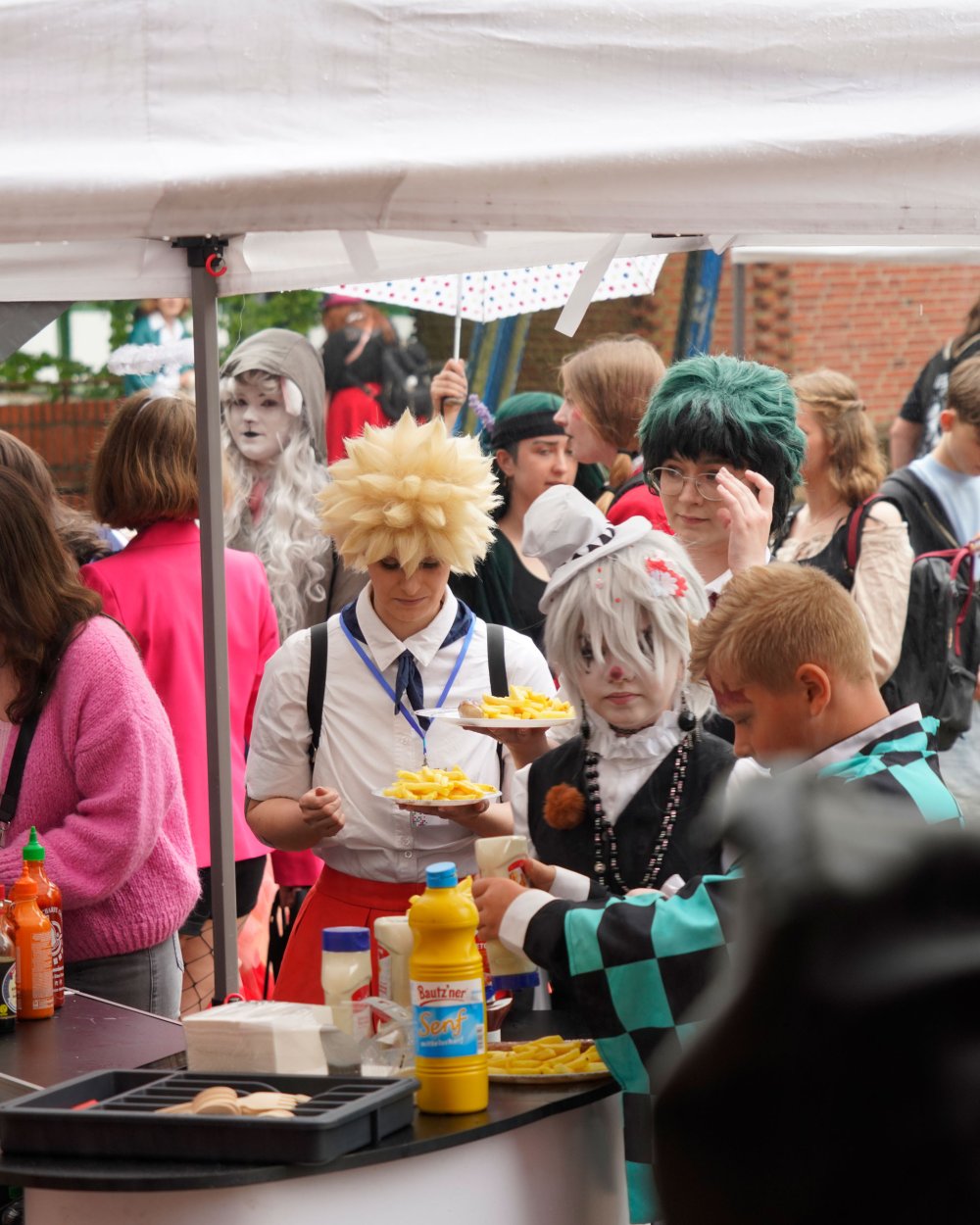Fast Food-Stand, an dem zahlreiche Studierende in Kostümen anstehen.