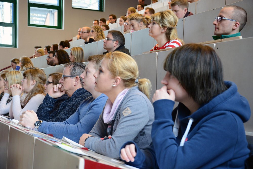 Erstsemesterstudierende sitzen im Hörsaal und hören den Begrüßungsreden zu. Bild aus 2015