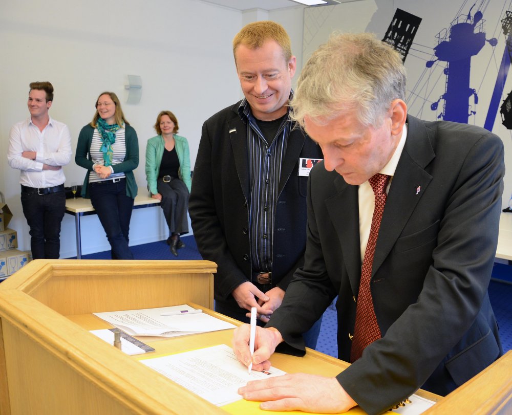 Hochschulpräsident Prof. Dr. Holger Watter unterzeichnet die Lübecker Erklärung im Beisein von Andreas Witolla, Landesvorstand des Lesben und Schwulenverbands in Deutschland. Foto: Gatermann