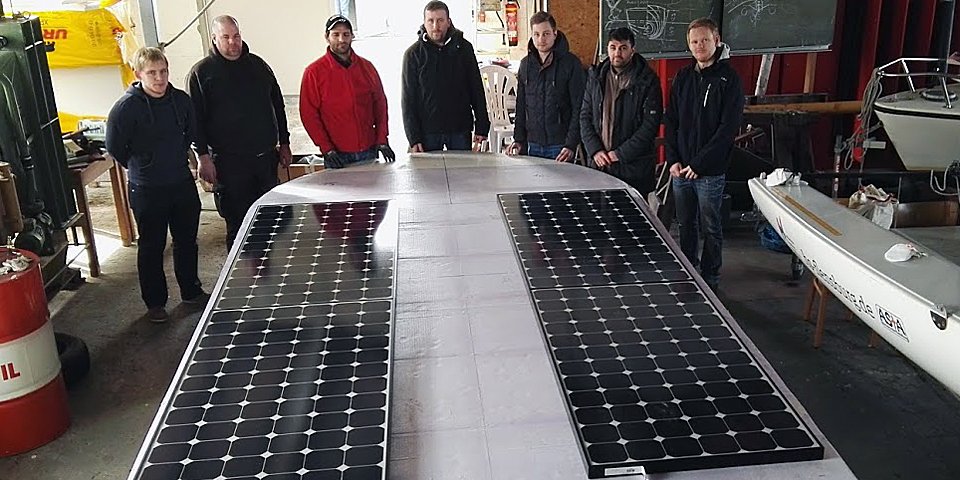 Die Studierenden vor Bauteilen des Solarbootes. 