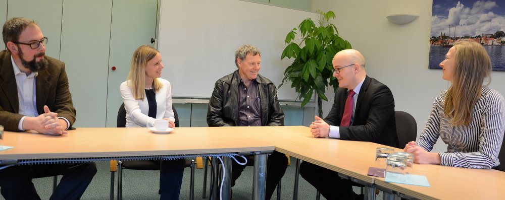 Masterstudentin Jana-Cathrien Müller (re.) holte Prof. Tony Paterson (Mitte) und Jörn Künsebeck (li.) nach Flensburg – zur Freude von Prof. Dr. Birte Nicolai und Bosco Lehr, Vizepräsident für Internationales.