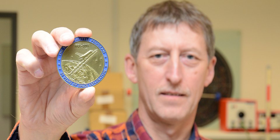 Stück aus dem Weltall: Rainer Christiansen zeigt die Medaille.
