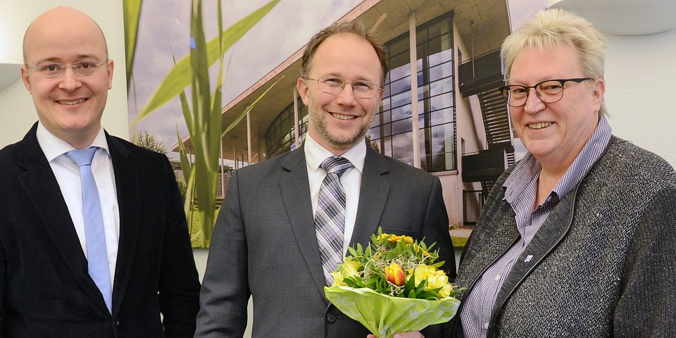 Farbenfroher Amtsantritt: Dr. Christoph Jansen wurde an seinem ersten Arbeitstag als neuer Präsident der Hochschule Flensburg von Kanzlerin Sabine Christiansen und Prof. Dr. Bosco Lehr, Vizepräsident für Internationales, mit einem Blumenstrauß empfangen. 