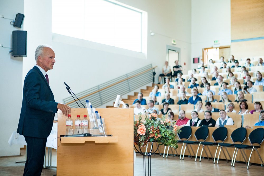Seitlicher Blick: Links im Bild der Festredner, rechts mehrere Reihen Publikum.