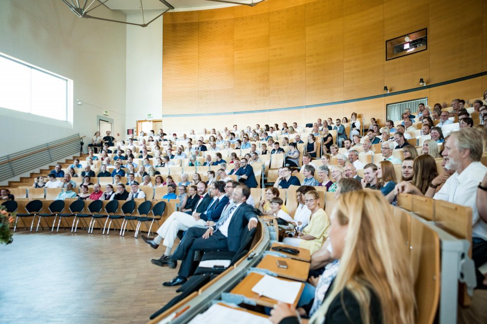 Blick ins Publikum, viele vollbesetzte Reihen.