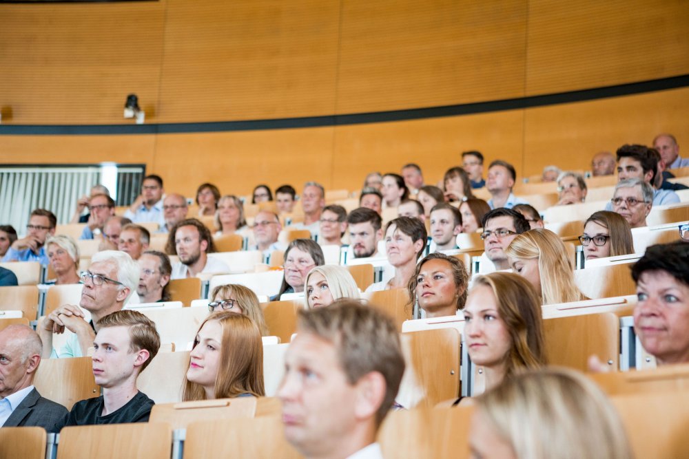 Einige Gäste im Publikum, sie schauen nach vorne.