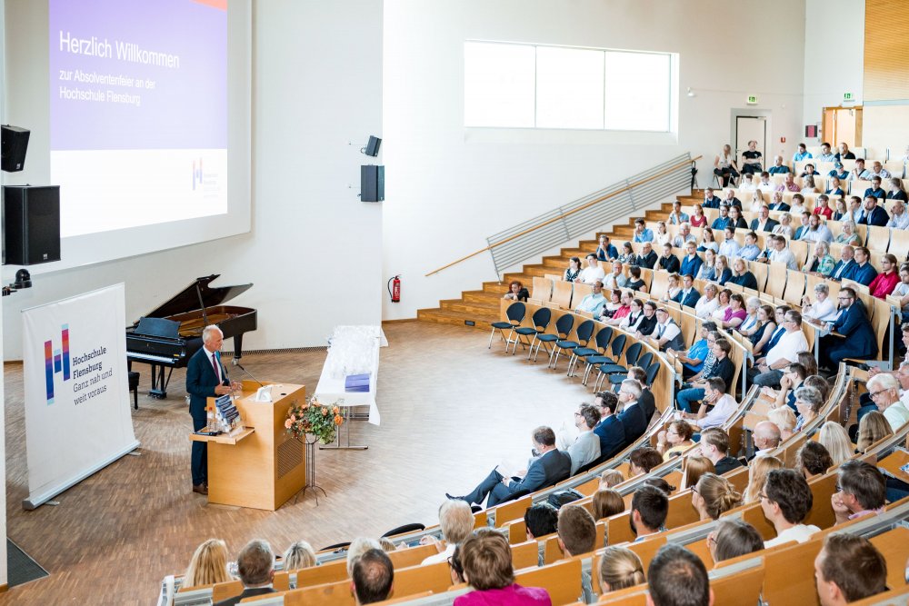 Blick von schräg hinten: Publikum und Festredner