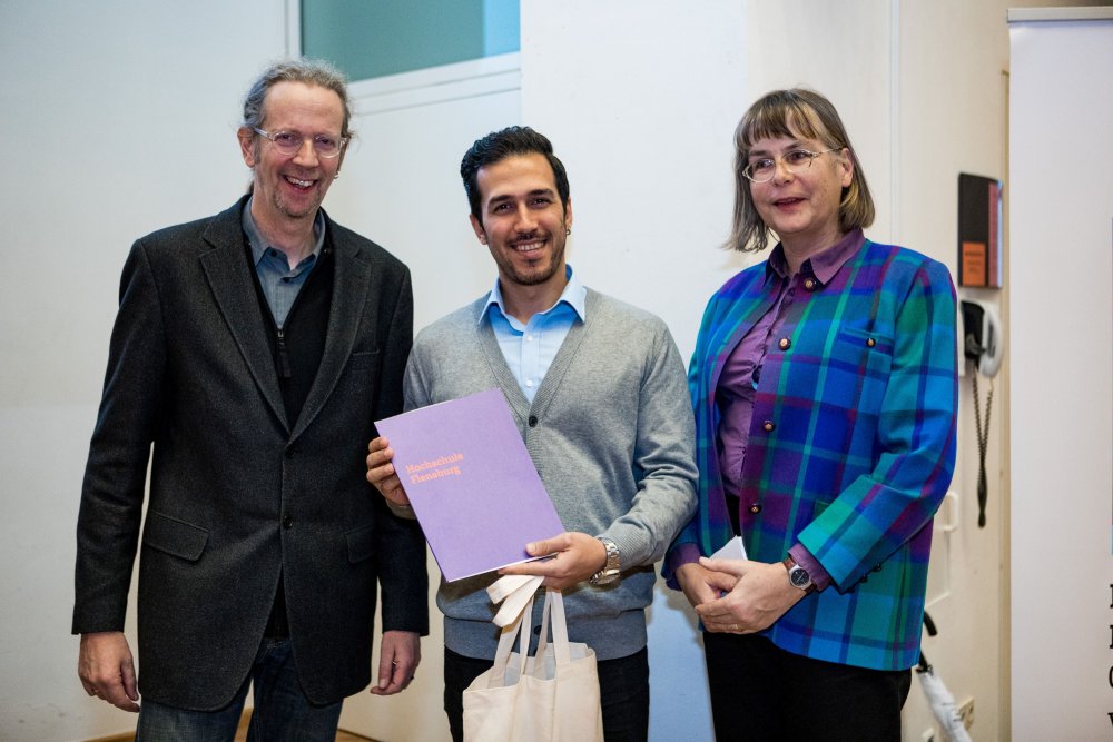 Prof. Torsten Steffen, Student Amir Asadi und Ute Sachau vom International Office posieren mit dem DAAD Preis.