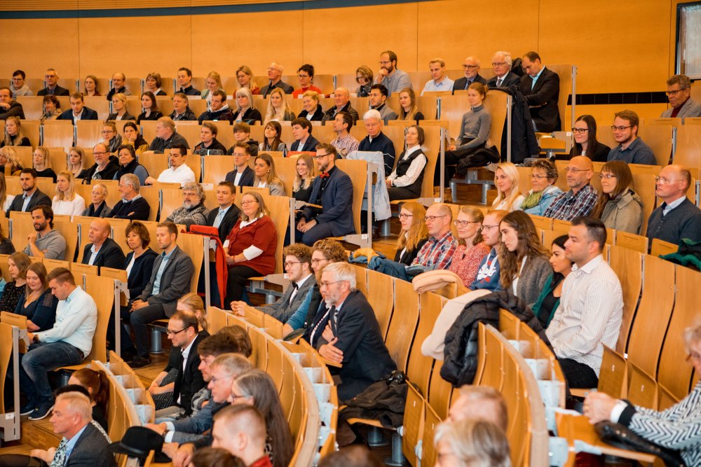 Blick ins Publikum: Menschen unterschiedlichen Alters und Aussehens, die meisten elegant gekleidet. Sie sehen überwiegend glücklich aus.