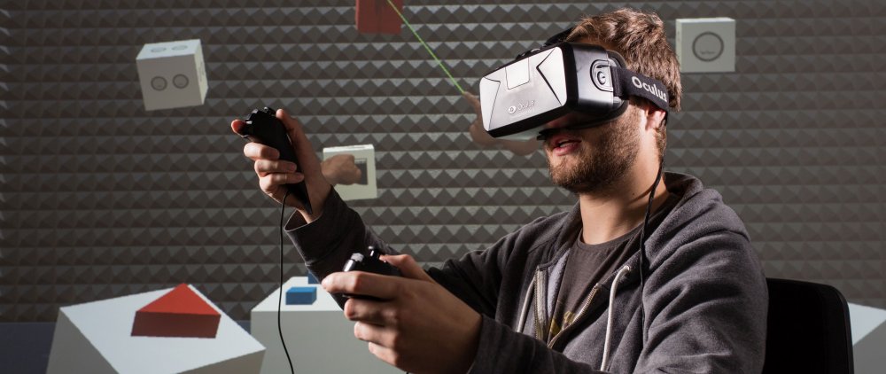 Junger Mann mit VR-Brille und je einem Controller in jeder Hand. Hinter ihm ist die virtuelle Umgebung erkennbar, in der er sich befindet.